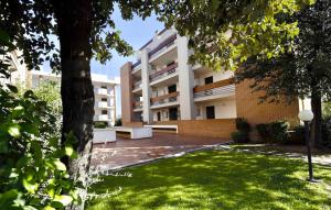 an apartment building with a bench in a yard at ISA - Apartments for 6 people, 2 bedrooms, in Residence Mirto And Corbezzolo with swimming pool in San Vincenzo in San Vincenzo