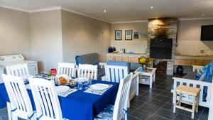 a dining room with a blue table and white chairs at The Sandcastle - Apartment in Villa in Witsand