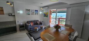 una sala de estar con una mesa y un sofá en SUPER FLAT 180 graus em Angra dos Reis , Frente Mar na Marina Piratas com estacionamento gratuito, en Angra dos Reis
