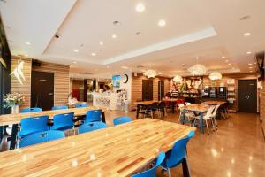 a restaurant with wooden tables and blue chairs at Hotel 88 Shinsaibashi in Osaka