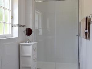 een witte badkamer met een douche en een spiegel bij Repton Cottage - 25348 in Findern