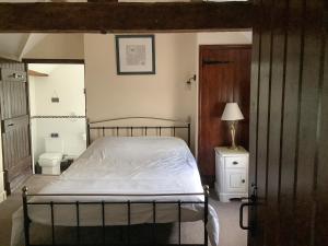 een slaapkamer met een bed en een toilet bij Repton Cottage - 25348 in Findern
