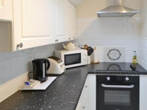 eine Küche mit einer Arbeitsplatte mit Mikrowelle in der Unterkunft Stable Cottage - Uk3285 in Guyzance