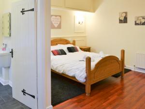 ein Schlafzimmer mit einem Bett mit weißen Laken und Kissen in der Unterkunft Stable Cottage - Uk3285 in Guyzance