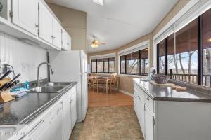 a kitchen with a sink and a refrigerator at Hideaway Chalet - Hot Tub in the Treetops, Arcade Games, + Close to Ober Mountain! in Chalet Village
