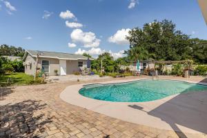a swimming pool in front of a house at Paradise Apartment in Orlando