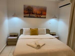 une chambre avec un lit avec deux serviettes dessus dans l'établissement Embassy Gardens Luxury Suites, à Accra