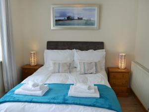 a bedroom with a bed with towels on it at The Honeypot in Padstow