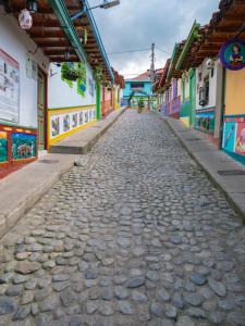 a cobblestone street in a town with colorful buildings at Descanso Bajo La Piedra Del Peñol in Guatapé +69 photos