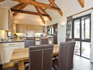 a kitchen with a wooden table and chairs at The Linhay in Little Petherick