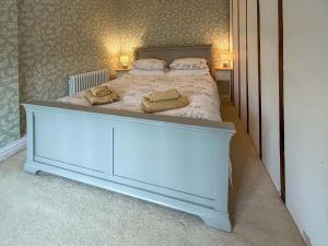 une chambre avec un lit avec deux serviettes dessus dans l'établissement Meadow Cottage, à Helhoughton