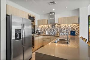 a kitchen with a stainless steel refrigerator and a sink at Eagle Beach - Palm by the Sea 2BR condo - LV207 in Palm-Eagle Beach
