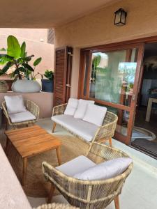 a patio with wicker chairs and a table at Sunset House in Costa Paradiso