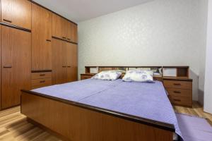 a bedroom with a bed and wooden cabinets at Apartment Kreso in Punat