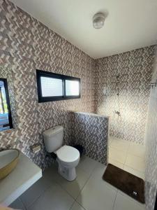 a bathroom with a toilet and a shower and a sink at La Casa Di Mantasoa - Lodge by the Lake in Mantasoa
