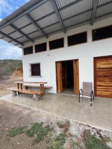 ein Haus mit einem Picknicktisch und einer Bank in der Unterkunft Good Time Charlie's Surf Hostel in San Juan del Sur