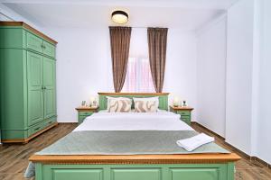 a green bedroom with a bed and a window at Primaverii Dream Residence in Chişoda