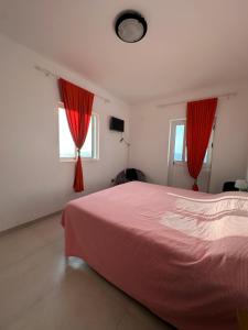 a bedroom with a pink bed and two windows at The edge of the Atlantic 