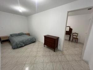 a bedroom with a bed and a dresser and a mirror at Maison cosy entre calme et nature in Laruscade