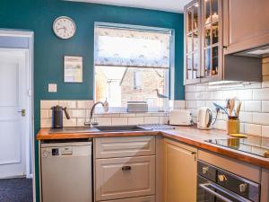 a kitchen with a sink and a clock on the wall at The Sandpiper in Filey
