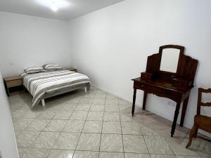 a bedroom with a bed and a mirror and a table at Maison cosy entre calme et nature in Laruscade +1 photo