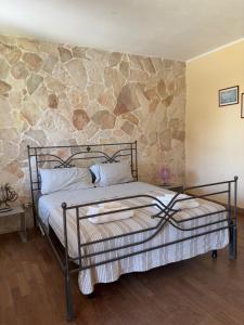 a bed in a room with a stone wall at Villa Donna Sibilla in Merine