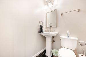 a white bathroom with a sink and a toilet at Cozy 3 bedroom and 2 bath Townhouse in Arlington +15 photos