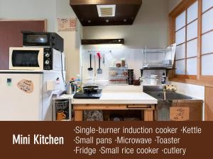 a kitchen with a white refrigerator and a sink at Suzuki Guesthouse in Kyoto +8 photos