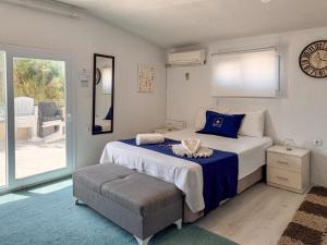 a bedroom with a bed and a chair and a clock at Villa Plaj in Kusadası