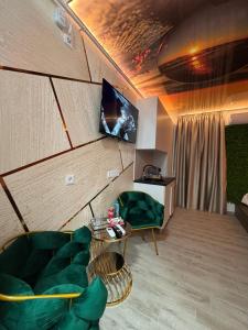 a living room with a green couch and a tv at MATTEO room by 50 shades in Baia Mare