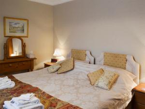 ein Schlafzimmer mit einem Bett mit zwei Kissen darauf in der Unterkunft Swallowtail Cottage - Uk2296 in Ebberston