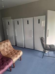 ein Raum mit einer Reihe von Kühlschränken und zwei Stühlen in der Unterkunft Direct Travel Stays in Cork