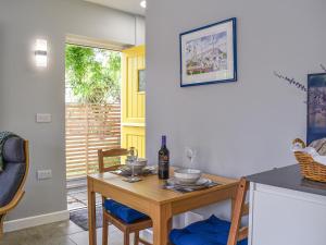 cocina con mesa y botella de vino en The Den, en Herne Bay