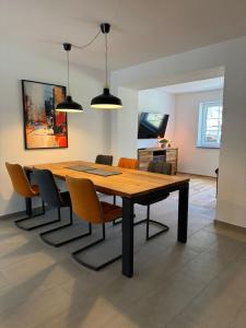 ein Esszimmer mit einem Holztisch und Stühlen in der Unterkunft Ferienwohnung in Oberschwaben in Schemmerhofen