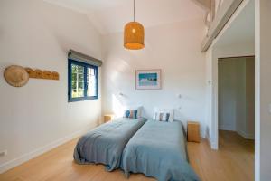 a bedroom with a bed with a blue comforter at Iparra -Elégance, confort près golf in Soorts-Hossegor
