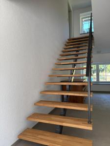 eine Treppe in einem Haus mit Holztreppen in der Unterkunft Ferienwohnung in Oberschwaben in Schemmerhofen