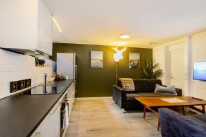 een keuken en woonkamer met een bank en een tafel bij Just steps behind the Royal Palace in Oslo