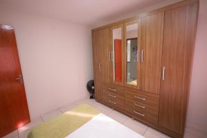 - une chambre avec des placards en bois et un miroir dans l'établissement Apartamento moderno e super aconchegante, à Campos dos Goytacazes