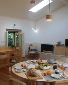 a living room with a table with food on it at Quintal do Forno l Casa da Hera in Paços da Serra