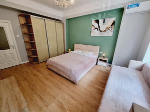 a bedroom with a bed and a green wall at 17-Avenue Apartment in Chernivtsi