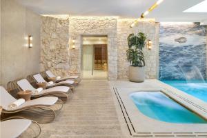 a hotel lobby with a pool and lounge chairs at H15 Palace, a Luxury Collection Hotel, Krakow in Krakow