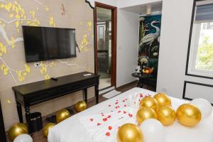 a room with two beds with balloons and a flat screen tv at Royal Lotus Villa HN in Hanoi