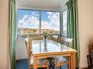 スワネージにあるSandringham Court Flat 4のダイニングテーブルと椅子、そして大きな窓