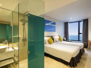 a hotel room with two beds and a bathroom at ibis Styles Nha Trang in Nha Trang