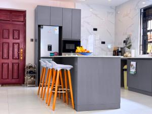 a kitchen with orange and white stools at a counter at Jay Jay Homes in Kampala