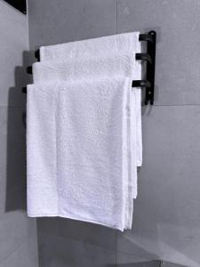 a white towel hanging on a towel rack in a bathroom at Jay Jay Homes in Kampala +13 photos