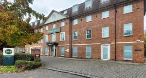 a large red brick building with a sign on it at B&B HOTEL London Heathrow in Hillingdon