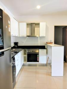 a kitchen with white cabinets and stainless steel appliances at Apartment near Shopping Mariscal in Asuncion +11 photos
