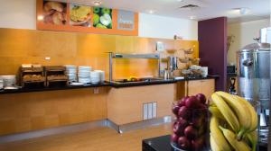 a kitchen with a counter with plates and fruit on a table at Holiday Inn Express Hemel Hempstead by IHG in Hemel Hempstead +30 photos