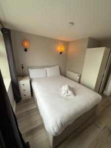 a bedroom with a large white bed and a night stand at Urban Lakeside Galway City Centre in Galway